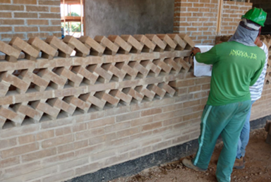 Figura 8: Montagem das paredes de vedação em blocos de adobe fabricados no canteiro de obras Nota:  Imagem fornecida pela equipe da Inova TS. Fonte: Os autores